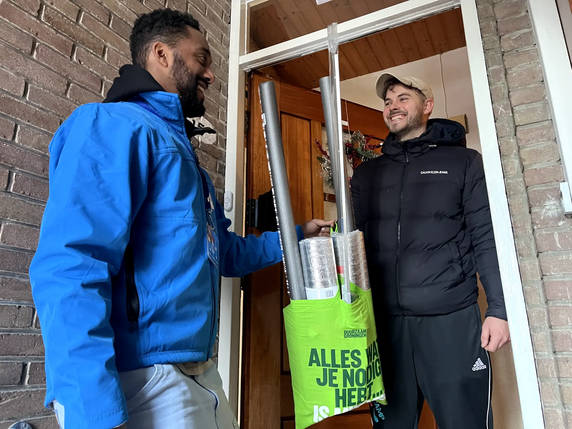 Warm de Winter in project waar PeperX werknemer isoleermateriaal overhandigt aan huishouden.