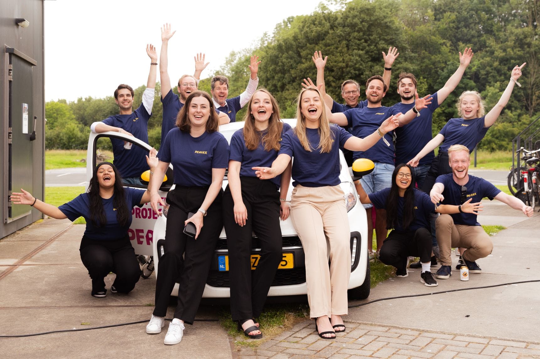 STUDENT-labs rebranding naar PeperX waar medewerkers met nieuwe kleding voor de bedrijfsauto poseren.